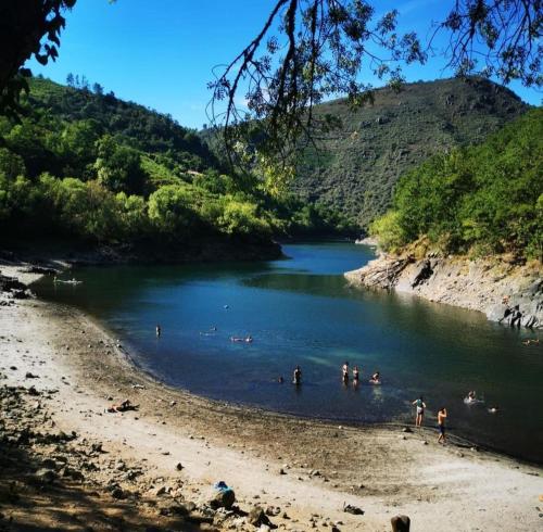 a group of people swimming in a river at Casa Leirón in Parada del Sil