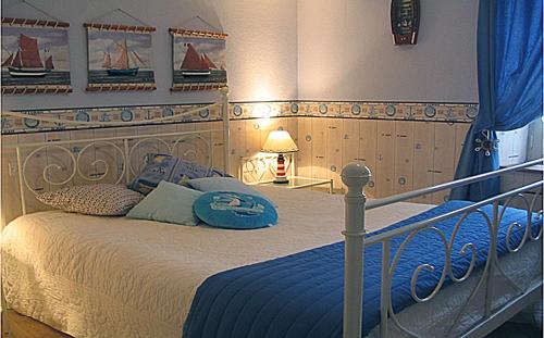 1 dormitorio con 1 cama grande con mantas y almohadas azules en Chez Martine et Bernard, en Saint-Vincent-Sterlanges