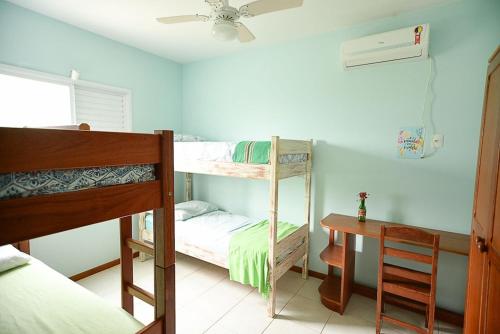 een slaapkamer met 2 stapelbedden en een bureau bij Casa aconchegante na praia da Daniela in Florianópolis