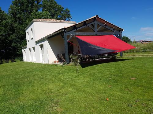 un edificio con una tenda rossa e nera in un cortile di Maison chaleureuse a Belleville-sur-Vie