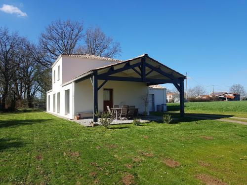 un grande edificio bianco con portico su un campo di Maison chaleureuse a Belleville-sur-Vie