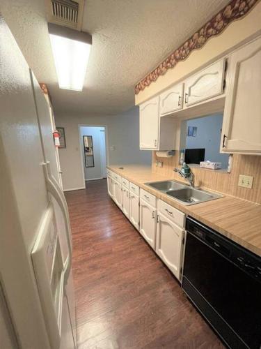 a kitchen with white cabinets and a black refrigerator at Super Cozy 4 Bedroom - Sleeps 10 Great for families and professionals in Katy