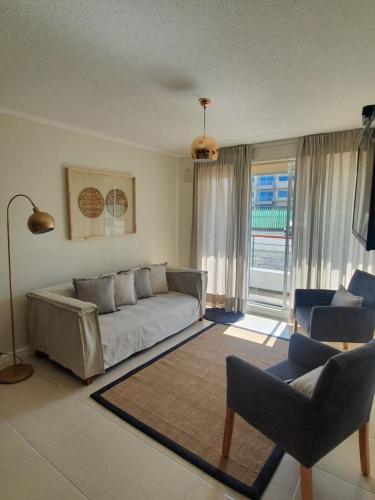 a living room with a couch and two chairs at Hermoso Departamento in El Tabo
