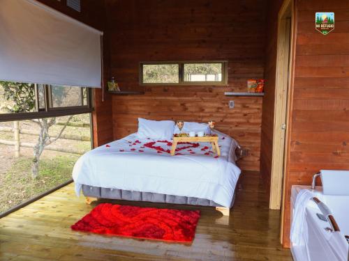 ein Schlafzimmer mit einem Bett in einem Blockhaus in der Unterkunft Cabaña Mi refugio in Guayabal de Síquima