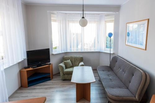 ein Wohnzimmer mit einem Sofa und einem TV in der Unterkunft Energetyczny Zakątek in Krzeszna
