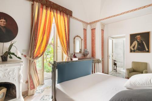 a bedroom with a bed and a fireplace at Vero Sicily - Sicilian Garden Cottages in Bagheria