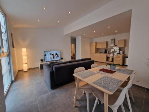 a living room with a table and a couch at Appart-Hotel Léopold Liège Centre in Liège