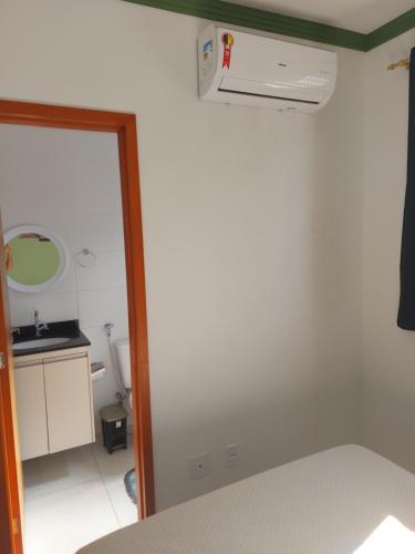 a bedroom with a ceiling fan and a mirror at Apartamento Resort Palmeiras 2 com 03 Quartos Ubatuba in Ubatuba