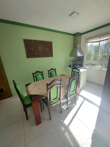 a kitchen with a dining room table and chairs at Apartamento Resort Palmeiras 2 com 03 Quartos Ubatuba in Ubatuba