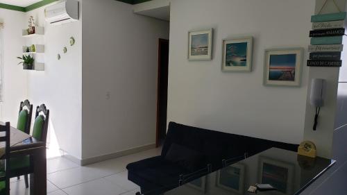 a living room with a chair and a glass table at Apartamento Resort Palmeiras 2 com 03 Quartos Ubatuba in Ubatuba