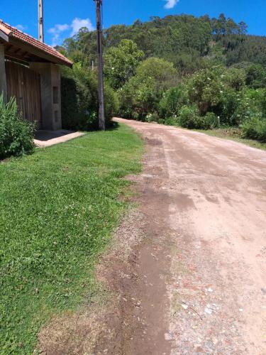 uma estrada de terra vazia ao lado de uma casa em Chalé MJF em Monte Verde