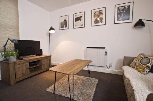 a living room with a table and a tv at Flat 1 Bellevue in Bristol