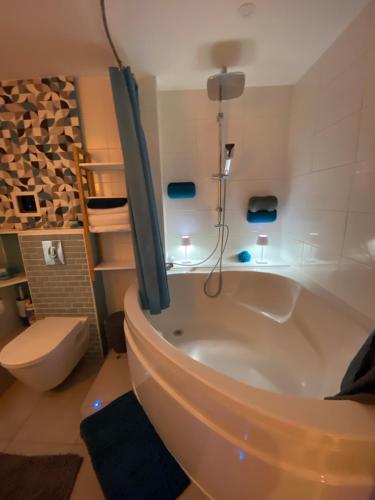 La salle de bains est pourvue d'une baignoire, de toilettes et d'un lavabo. dans l'établissement Cosy courcelles, à Paris