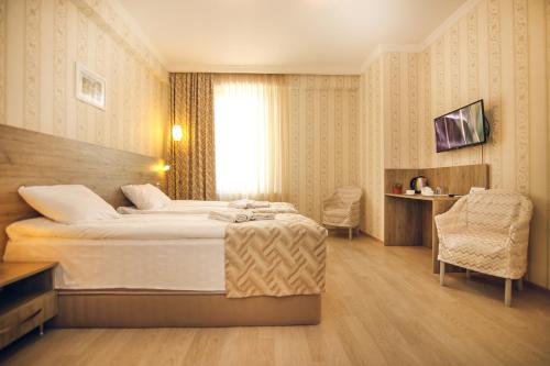 a hotel room with a bed and a chair at Hotel Kera in Tbilisi City