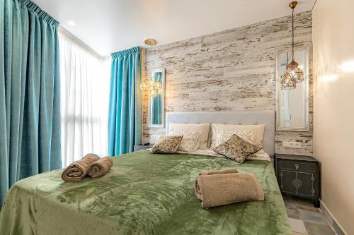 Un dormitorio con una cama verde con toallas. en Luxury two-bedroom apartment Four Seasons en Adeje