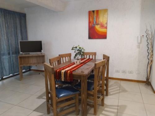 uma sala de jantar com uma mesa e cadeiras e uma televisão em Terracota lodge em Guaymallén