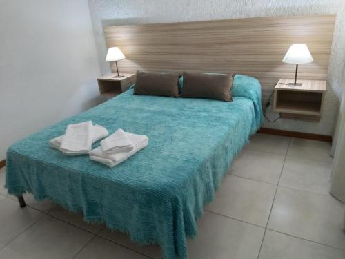 a bedroom with a blue bed with two towels on it at Terracota lodge in Guaymallen