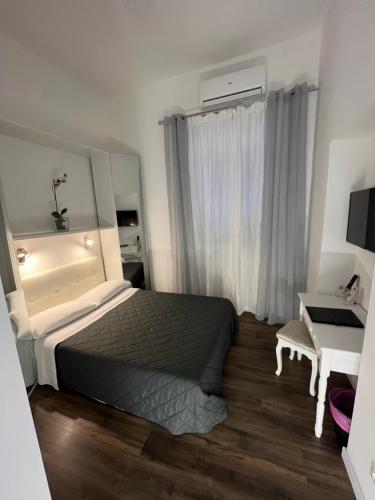 a bedroom with a bed and a desk and a window at Domus Flavia B&B in Rome