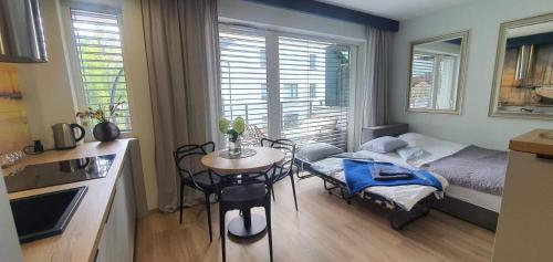 a small room with a table and a bed and a kitchen at Apartament na turystycznej in Ostróda
