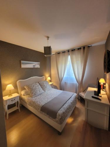 une chambre avec un lit blanc et une fenêtre dans l'établissement Le Papé logement meublé tourisme 3 étoiles, à Villers-sur-Mer