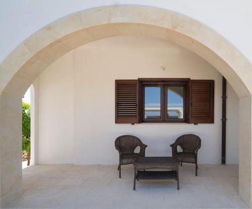 an archway with two chairs and a table on a patio at Podere Santa Chiara in Otranto