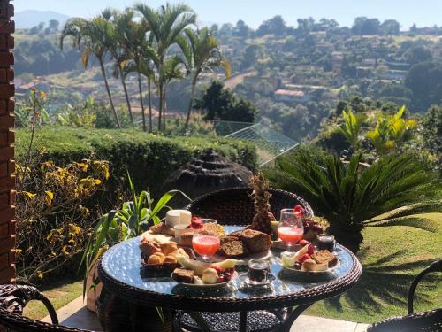 a tray of food sitting on a table with a view at CHACARA THA&THI COND FECHADO WI FI SPA e PISC AQUECECIMENTO SOLAR in Bom Jesus dos Perdões