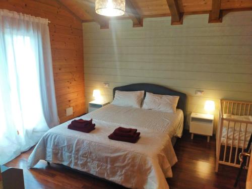 una camera da letto con un letto con due asciugamani sopra di Chalet Collalto con Piscina a Cerratina