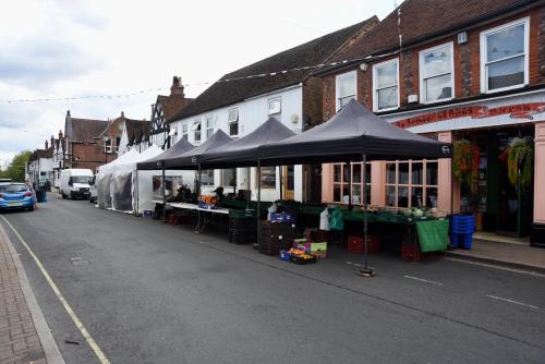 a street with a farmers market with umbrellas at Lancing Apartments - Spacious 2 Bed - Sleeps 6 - Burnham Village in Slough