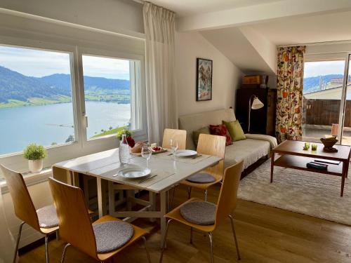 a living room with a table and chairs and a couch at Beautiful apartment with fantastic views in Oberägeri