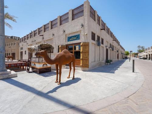 a statue of a camel in front of a building at Heritage Home Guest House in Dubai