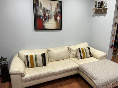 a white couch in a living room with a painting at Gran Apart Hotel Chillan - Monte Piedra - Factura Empresas - Parking - wifi - servicio adicional pensión completa in Chillán