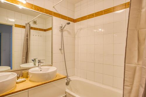 une salle de bain avec un lavabo, une baignoire et un miroir dans l'établissement Part Dieu, très belle résidence, à Lyon