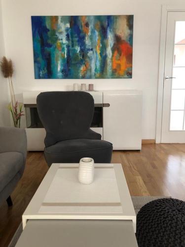 a living room with a chair and a table at Apartment Arena Lux in Fontana