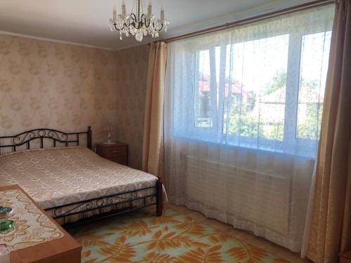 1 dormitorio con cama y ventana grande en Künni majutus en Viljandi