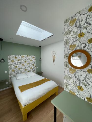a bedroom with a large bed and a mirror at L'étoile de mer- la dune fleurie in Gravelines