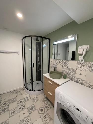 a bathroom with a shower and a washing machine at L'étoile de mer- la dune fleurie in Gravelines