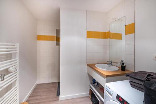 La salle de bains est pourvue d'un lavabo et d'un miroir. dans l'établissement La Grue Jaune, à Nantes