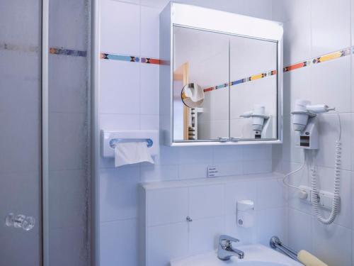 a white bathroom with a sink and a mirror at Haus Amberger in Bayerisch Gmain