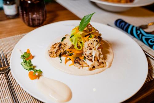 a white plate with a dish on a table at Casa Paradis Boutique Hotel in Jambiani