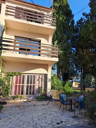 a house with a table and chairs in front of it at Apartmani Svitlana in Sukošan