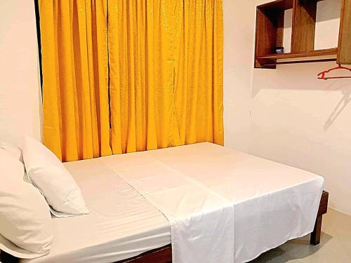 a bed in a room with an orange curtain at LADY GHAGHA ROOM RENTALs in San Vicente