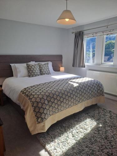 a bedroom with a large bed and a window at Romany Cottage B&B in Buckden