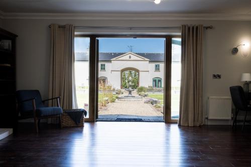 una puerta abierta a una casa grande con patio en Escape Ordinary at Castle Hume en Enniskillen