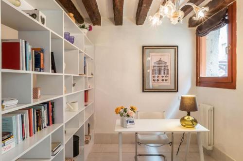 een kamer met een wit bureau en boekenplanken bij Ca Molin by Venicevillas, vista canale in Venetië
