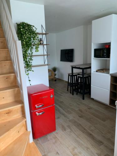 um frigorífico vermelho num quarto com uma mesa em Petite Maison Cosy em Saint-Brieuc