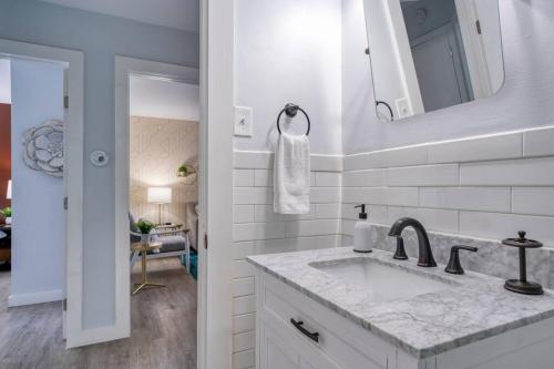 Baño blanco con lavabo y espejo en 2BR Duplex King Beds in the city- Great for small groups close to all Uptown Charlotte attractions, en Charlotte