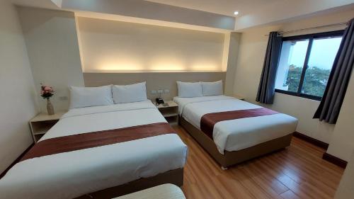 a hotel room with two beds and a window at 456 Hotel in Baguio