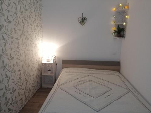 Un dormitorio pequeño con una cama y una lámpara. en Petite villa avec piscine privative, en Aigremont