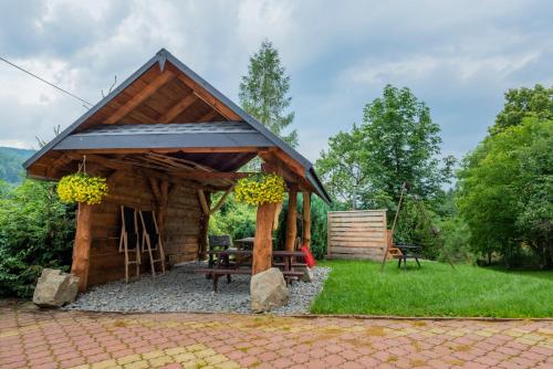 a pavilion with a picnic table in the grass at Agroturystyka Górski Wypoczynek in Stryszawa