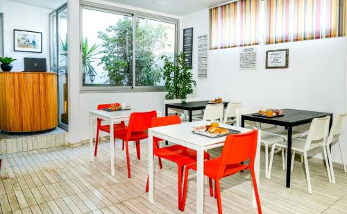 a restaurant with red chairs and tables and a window at Manzil Hotel in Casablanca